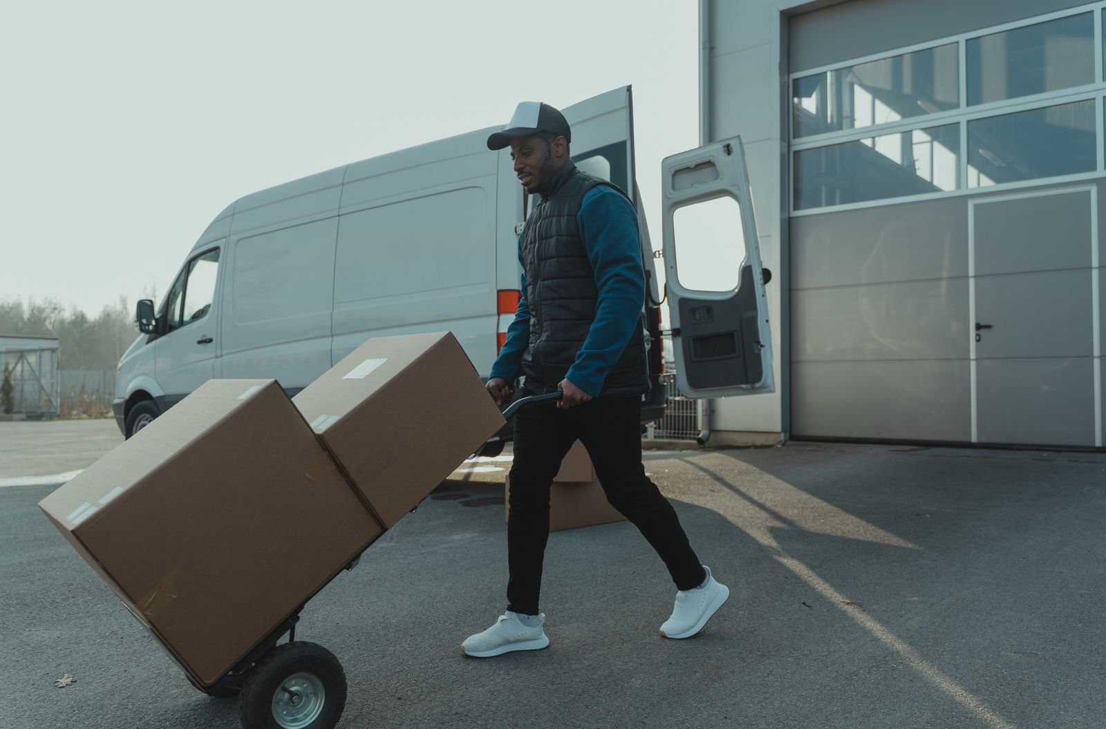 Delivery worker wheeling boxes to a van