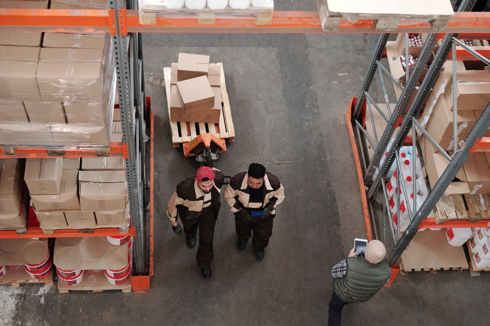 Warehouse staff moving stock between racks of boxes