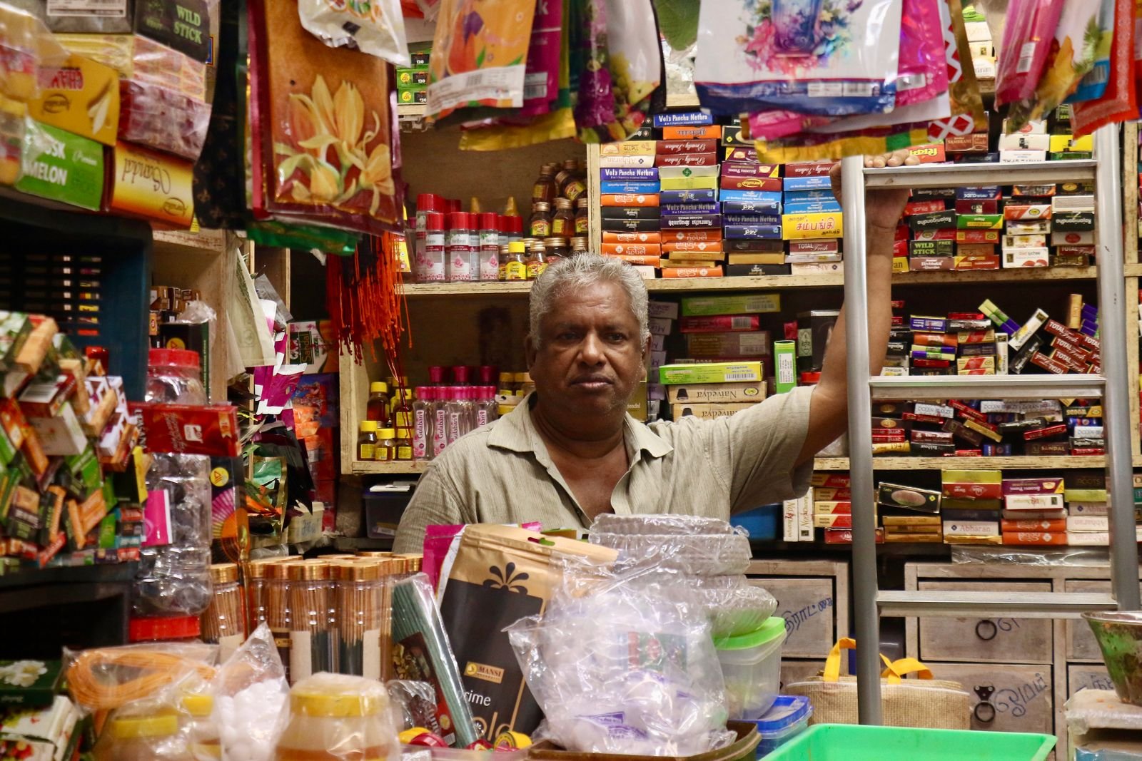 Shopkeeper at the counter of a busy Indian general store