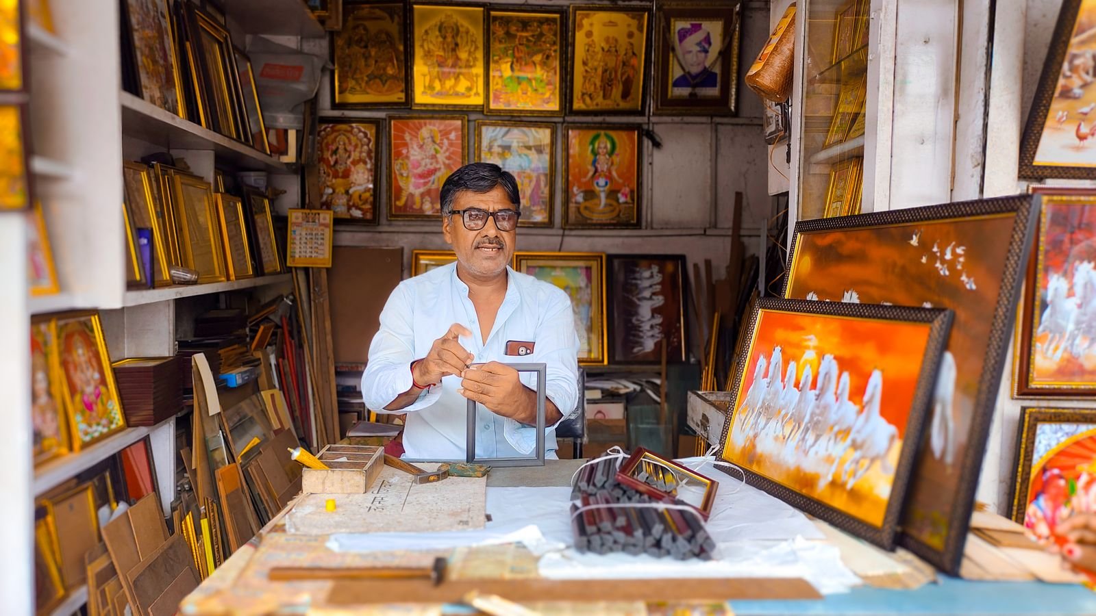 Shop owner at the counter of a small picture-framing shop