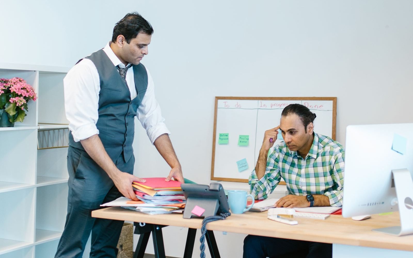 Office staff sorting a pile of paper files