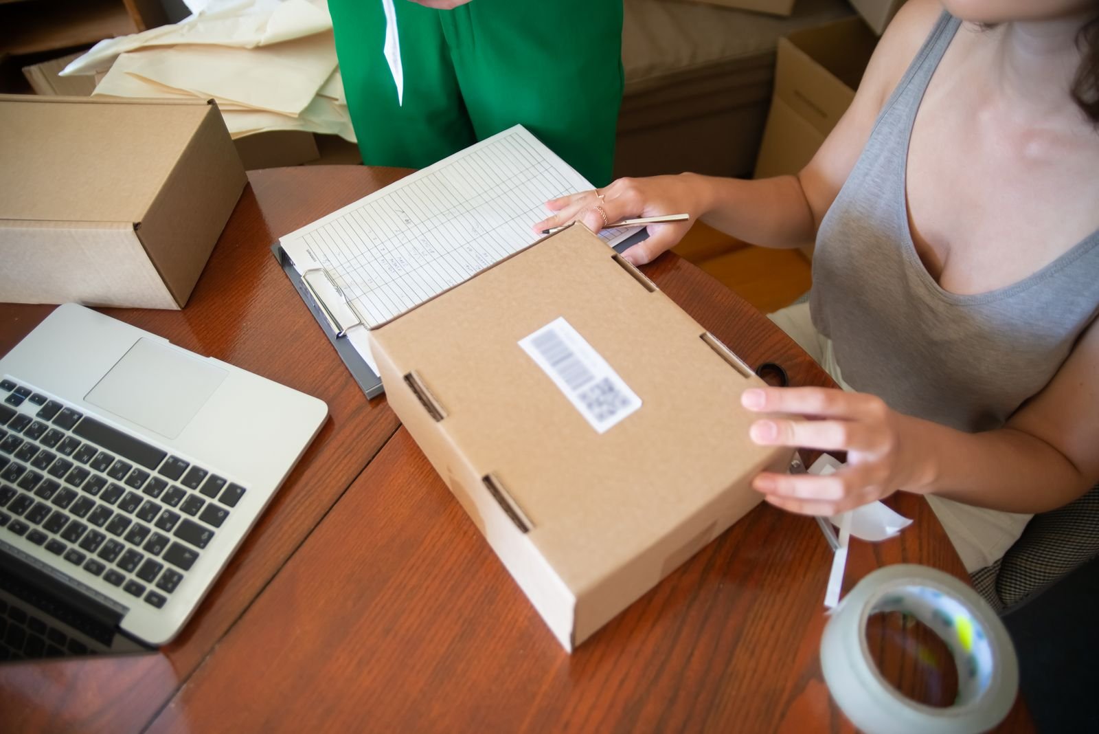 Seller packing an online order into a labelled cardboard box