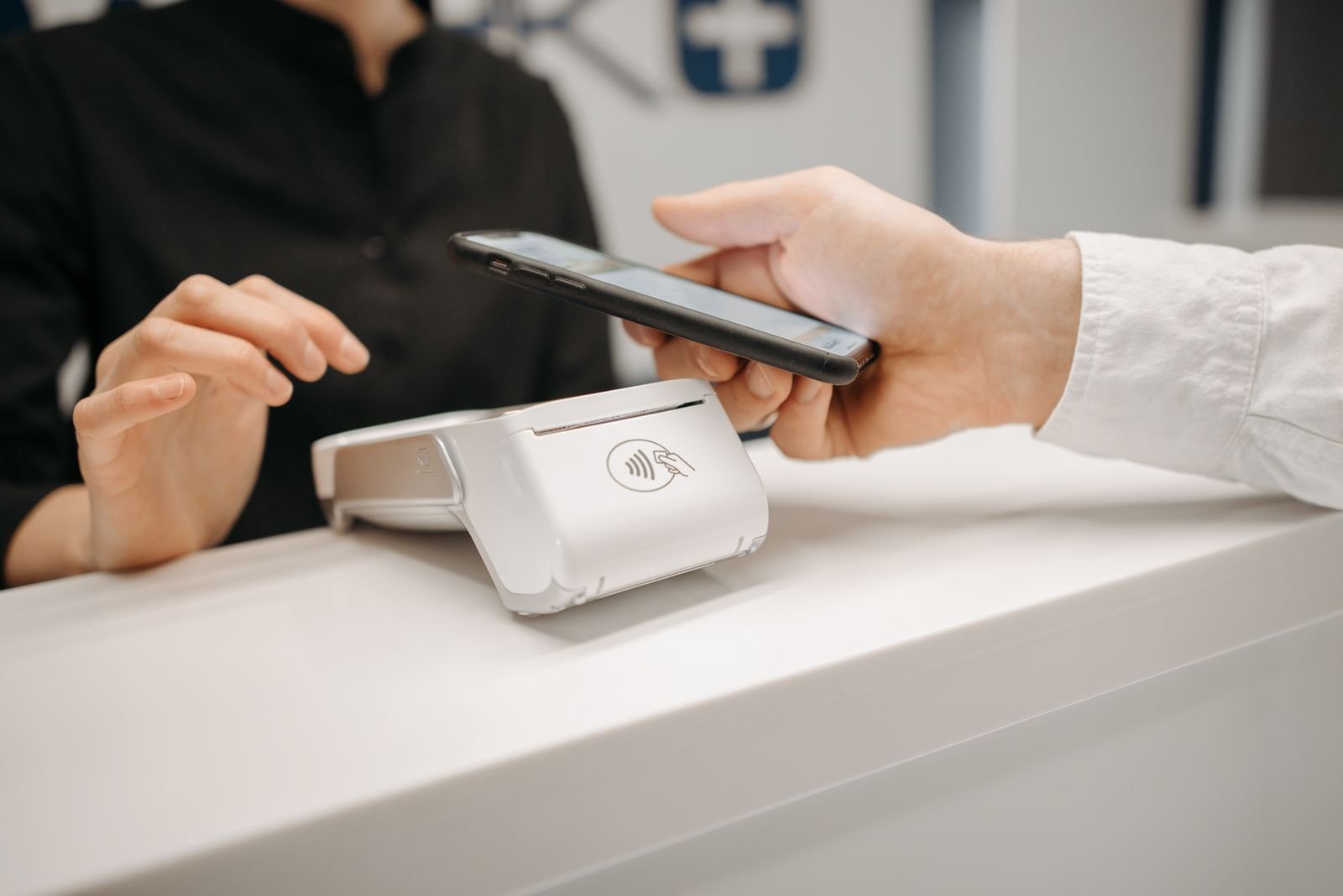Customer paying with a phone at a shop counter