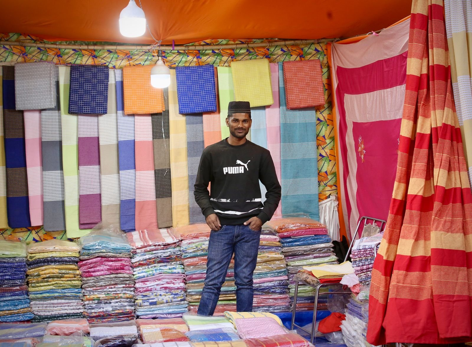 Rolls of colourful fabric displayed at a market stall